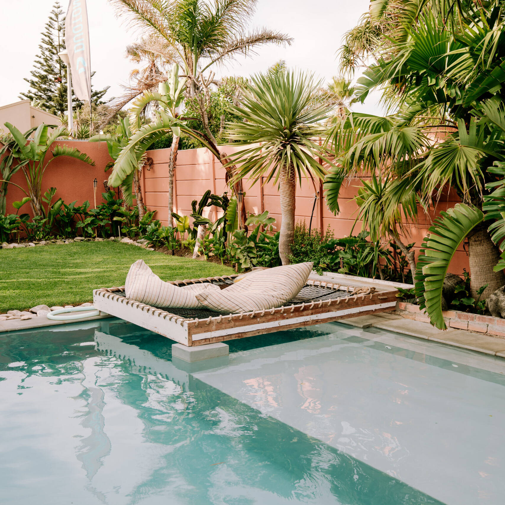 Garden of the Surfers Lodge in Blouberg, Cape Town with hammock lounge and tropical area.