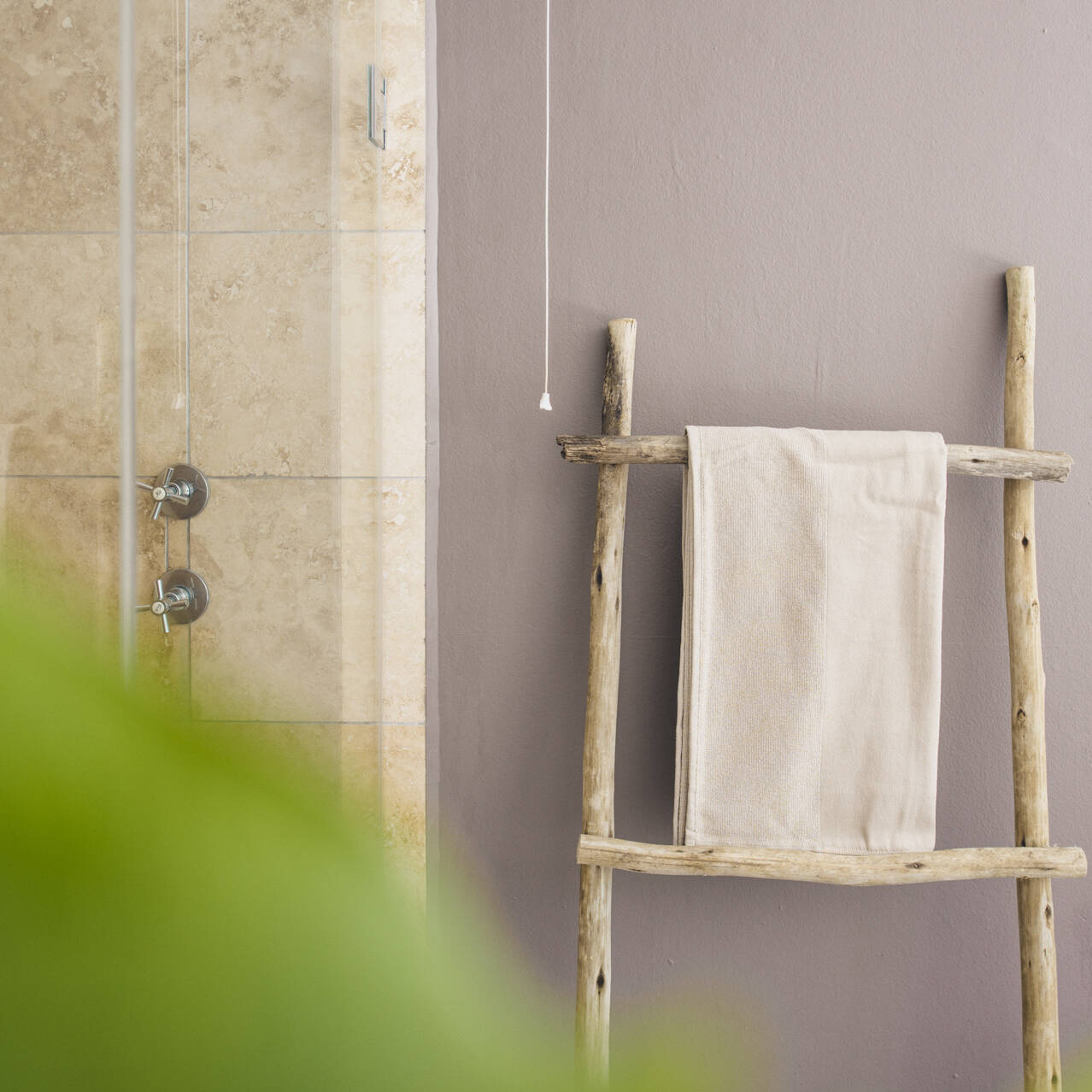 Bathroom with wooden towel ladder and beige tiled shower area in the poolside double room at Cape Town Surfers Lodge.